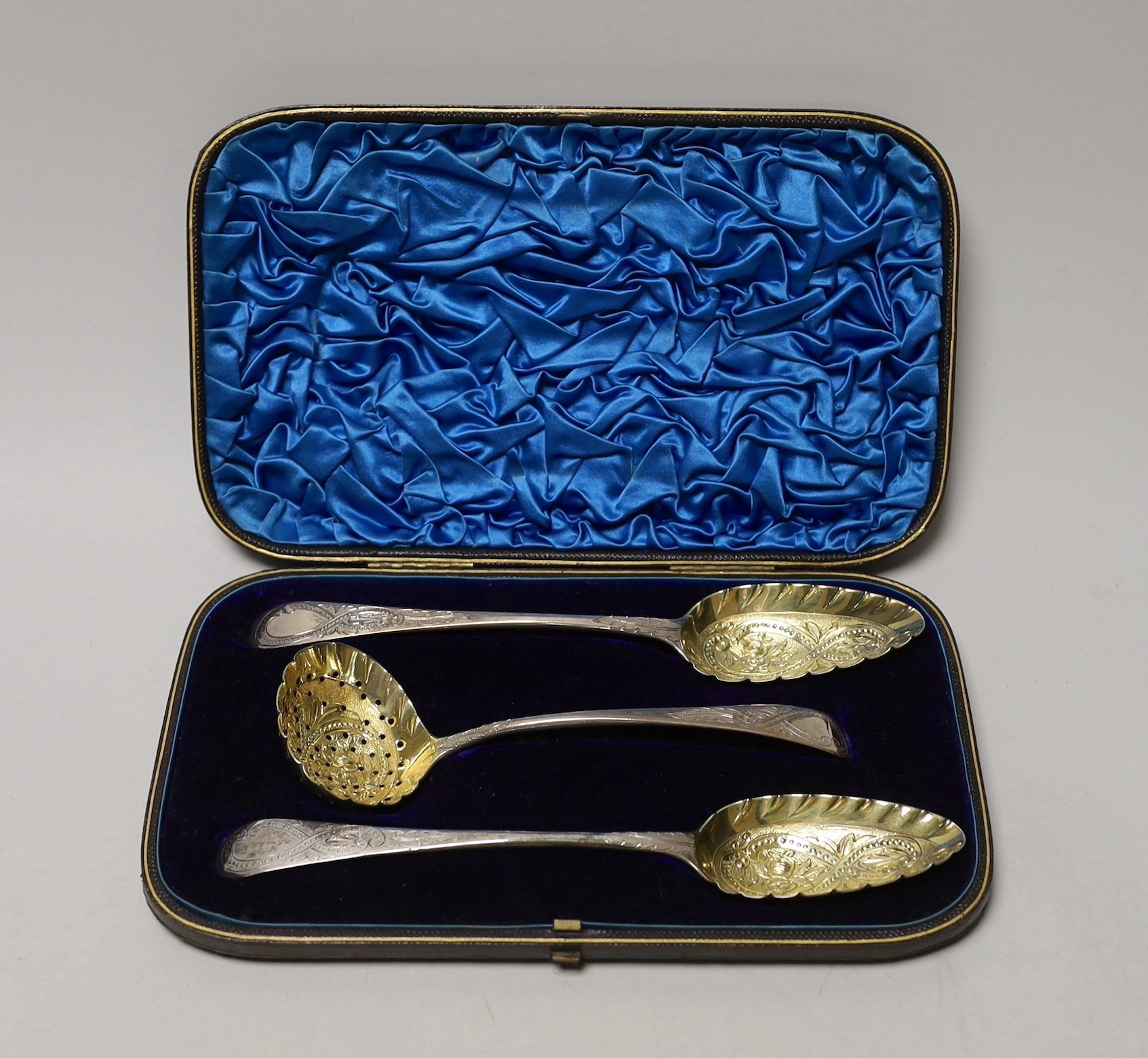 A cased set of two George III parcel gilt silver spoons and a matching sifter spoon, George Burrows, London, 1795 and George & Alice Burrows, London, 1802, largest 22.1cm.